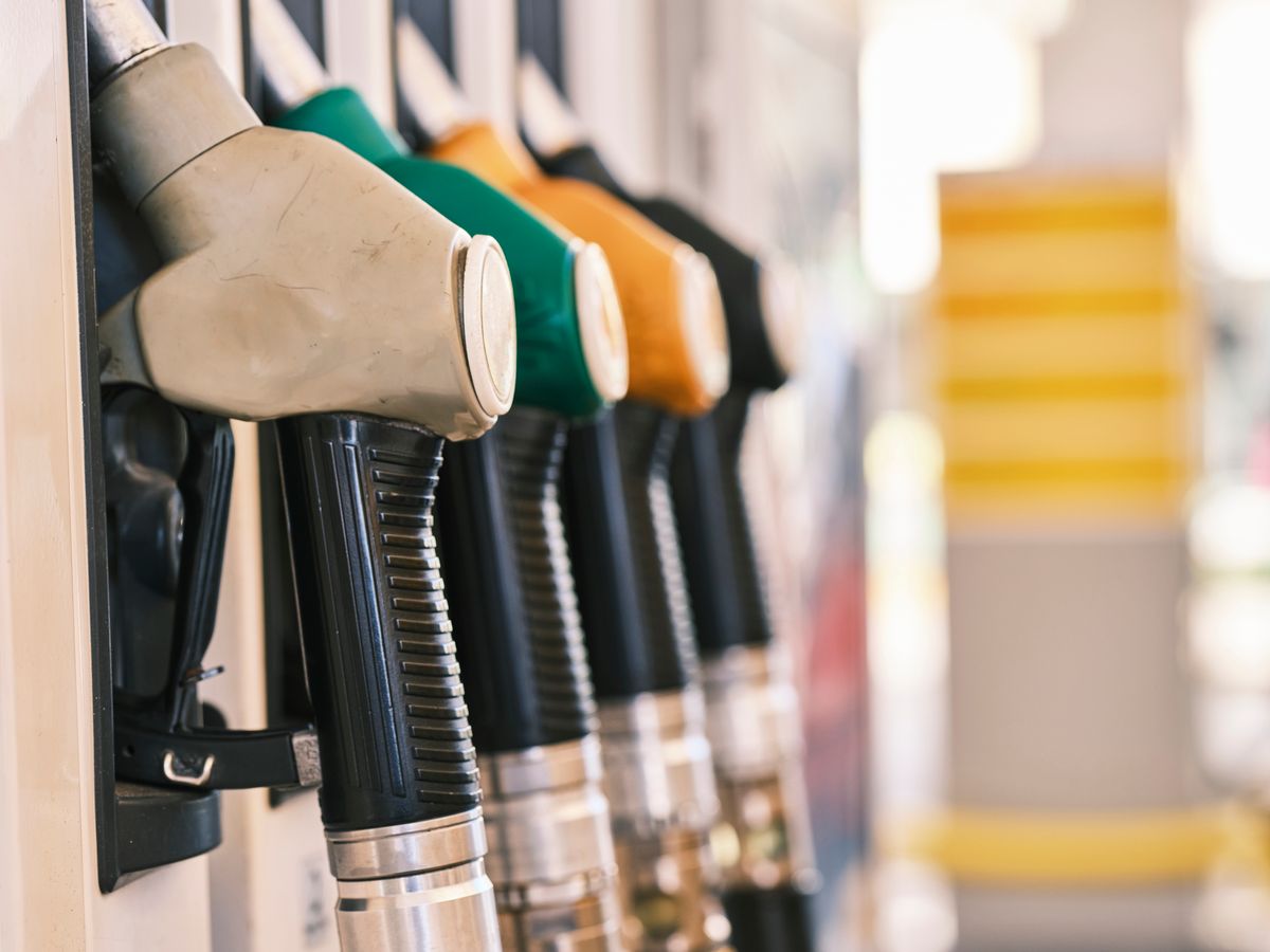 Fuel dispenser nozzles holstered on a forecourt pump.